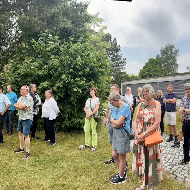 Die Besuchergruppe bewegt sich zwischen Eingang und Außenbereich.