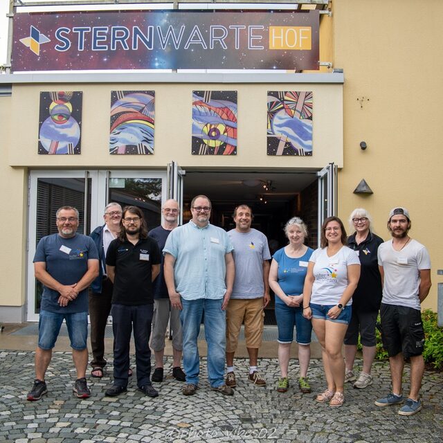 Helferinnen und Helfer des Astroteams posieren vor der Fassade der Sternwarte.