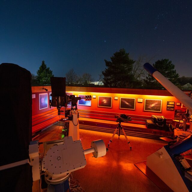 Beobachtungsbühne der Sternwarte Hof bei Nacht mit Teleskopen, roter Beleuchtung und Sternenhimmel